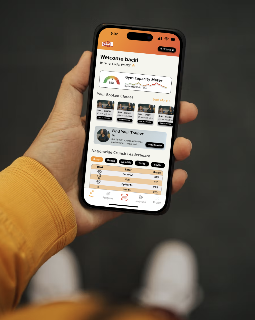 Hand holding phone displaying redesigned Crunch Fitness mobile app